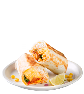 A plate with two halves of a grilled breakfast burrito filled with eggs, vegetables, rice, and corn, garnished with lime wedges and served with salsa.