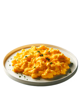 A plate of creamy scrambled eggs garnished with finely chopped herbs.