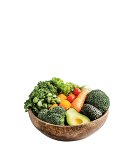 A rustic wooden bowl filled with assorted fresh vegetables including avocado, broccoli, carrots, tomatoes, kale, lettuce, and snap peas.